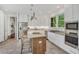 Spacious kitchen featuring white cabinets, granite countertops, stainless steel appliances, an island, and barstool seating at 3 Yancey, Pittsboro, NC 27312