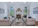 Bright living room with fireplace, two sofas, hardwood floors, rug, and plenty of natural light from the windows at 3 Yancey, Pittsboro, NC 27312