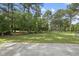 A wide-angle shot of a backyard with green grass, a shed, and a concrete slab at 30 Cornerstone Dr, Franklinton, NC 27525