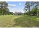 Backyard featuring grass, mature trees, and a house in the distance with a chimney at 30 Cornerstone Dr, Franklinton, NC 27525