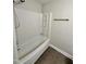 Bathroom with white tub and shower combination with silver hardware and vinyl floors at 3047 Huntleigh Dr, Raleigh, NC 27604