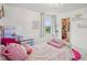 Cozy bedroom with white furniture, pink accents, and a glimpse into a well-organized closet at 316 Wellwater Ave, Durham, NC 27703