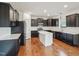 Modern kitchen with dark cabinets, stainless steel appliances, white subway tile backsplash, and island at 316 Wellwater Ave, Durham, NC 27703