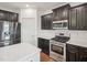 Close-up of the kitchen features stainless steel appliances, dark cabinets, and white countertops at 316 Wellwater Ave, Durham, NC 27703