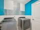 A modern laundry room featuring mosaic tile detail, geometric flooring, and front load washer and dryer units at 316 Wellwater Ave, Durham, NC 27703