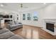 Bright and spacious living room featuring hardwood floors, fireplace, large windows, and modern decor at 316 Wellwater Ave, Durham, NC 27703