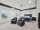 Spacious bedroom with ample natural light, elegant four-poster bed, and two comfortable sitting chairs at 316 Wellwater Ave, Durham, NC 27703