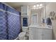 Bathroom features a large white vanity, blue shower curtain, and a built-in linen cabinet at 3216 Nc Hwy 42, Willow Springs, NC 27592