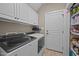 Functional laundry room with white cabinetry, modern washer and dryer units, and storage shelves at 3216 Nc Hwy 42, Willow Springs, NC 27592
