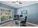 Well-lit home office with two desks, a large window, and a wall-mounted TV at 3309 Turner Ridge Dr, New Hill, NC 27562
