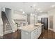 Open-concept kitchen boasts white cabinets, granite countertops, a large island, and dark hardwood floors at 3309 Turner Ridge Dr, New Hill, NC 27562