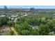 An aerial view showcases homes nestled within a lush, green canopy of trees, with buildings in the background at 3323 Cheswick Dr, Raleigh, NC 27609