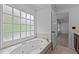 Luxurious soaking tub with jets, set under a window, creating a spa-like retreat at 3323 Cheswick Dr, Raleigh, NC 27609