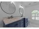 Elegant bathroom featuring a dual vanity with marble countertop and two round mirrors at 3323 Cheswick Dr, Raleigh, NC 27609