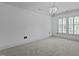 Bright, airy bedroom featuring a chandelier and large windows with plantation shutters at 3323 Cheswick Dr, Raleigh, NC 27609