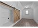 Walk-in closet with custom storage, modern lighting, and rustic sliding barn door at 3323 Cheswick Dr, Raleigh, NC 27609