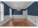 Charming dining room featuring beautiful hardwood floors, a decorative chandelier, and classic wainscoting at 3323 Cheswick Dr, Raleigh, NC 27609