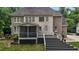 View of the home's rear featuring a spacious deck, screened-in porch, and brick accents at 3323 Cheswick Dr, Raleigh, NC 27609