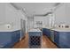 Open-concept kitchen with a center island, stainless steel appliances, and custom blue and white cabinetry at 3323 Cheswick Dr, Raleigh, NC 27609