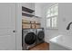 Modern laundry room with new washer, dryer, sink, storage, and natural light from the window at 3323 Cheswick Dr, Raleigh, NC 27609