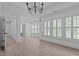 Bright living room with hardwood style floors, neutral walls, chandelier, and lots of windows at 3323 Cheswick Dr, Raleigh, NC 27609