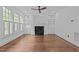 Bright living room with a fireplace, built-in shelving, plantation shutters, and hardwood floors at 3323 Cheswick Dr, Raleigh, NC 27609