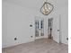 Spacious room featuring wood tile flooring, elegant lighting fixture, and French door access at 3323 Cheswick Dr, Raleigh, NC 27609