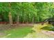 Spacious backyard with mature trees, a small deck and a wooded fence line at 3401 Sitzman Ct, Raleigh, NC 27616