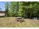 Backyard with a wooden picnic table in a wooded area at 3504 Lexham Ct, Apex, NC 27539