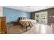 Cozy bedroom featuring hardwood floors, a queen sized bed, an adjacent door with balcony access at 3504 Lexham Ct, Apex, NC 27539