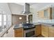 Modern kitchen showcasing stainless steel oven and hood, modern cabinets, updated countertops and backsplash at 3504 Lexham Ct, Apex, NC 27539