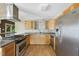 Bright kitchen featuring stainless steel appliances, wood cabinets, updated countertops and backsplash, and hardwood floors at 3504 Lexham Ct, Apex, NC 27539