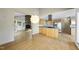 Bright open kitchen with hardwood floors, stone fireplace, stainless steel appliances, and modern lighting fixture at 3504 Lexham Ct, Apex, NC 27539