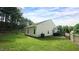 Back exterior of home with a large, grassy yard and firepit at 3709 Fan Palm Ct, Raleigh, NC 27616