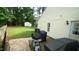 Backyard patio area with space for outdoor dining and grilling, next to the well-maintained lawn at 3709 Fan Palm Ct, Raleigh, NC 27616