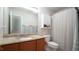 Bathroom with a granite countertop vanity, a framed mirror, and a shower-tub combo with curtain at 3709 Fan Palm Ct, Raleigh, NC 27616