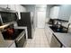Streamlined kitchen boasts stainless steel appliances, modern lighting and tile floor at 3709 Fan Palm Ct, Raleigh, NC 27616