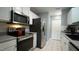 Efficient kitchen with stainless steel appliances, ample cabinets, and tile floors at 3709 Fan Palm Ct, Raleigh, NC 27616