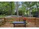 Relaxing wooden back deck featuring seating, a bench, and a lovely treed backyard at 4 Weathergreen Ct, Durham, NC 27713