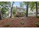 View of a charming two-story home with a deck, set amidst a lush, green backyard at 4 Weathergreen Ct, Durham, NC 27713