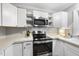 Modern kitchen with stainless steel appliances, white cabinets, and ample counter space at 4 Weathergreen Ct, Durham, NC 27713