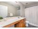 Neutral toned bathroom featuring a large countertop, shower with curtain, and tile floor at 405 Challenge Rd, Raleigh, NC 27603
