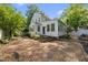 Charming backyard with brick patio, lush greenery, and white picket fence perfect for outdoor entertaining at 406 E Lee St, Smithfield, NC 27577