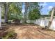 The backyard has a brick patio and mature landscaping with a white fence at 406 E Lee St, Smithfield, NC 27577