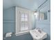 Charming bathroom features light blue walls, pedestal sink, and window with natural light at 406 E Lee St, Smithfield, NC 27577
