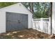 Detached garage with carriage doors surrounded by lush greenery adding rustic charm to the property at 406 E Lee St, Smithfield, NC 27577