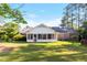 Lush backyard featuring a screened porch, mature trees, and a well-manicured lawn at 411 W Killiegrey St, Lillington, NC 27546