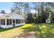 Large, grassy backyard with a screened porch and storage shed surrounded by trees at 411 W Killiegrey St, Lillington, NC 27546