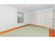Bedroom with light green carpet, a window, and white closet doors at 411 W Killiegrey St, Lillington, NC 27546