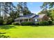 Angle shot of home highlighting mature landscaping and front covered porch at 411 W Killiegrey St, Lillington, NC 27546